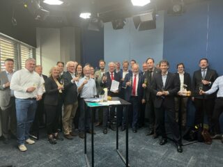 Alle ondertekenaars staan bij elkaar en heffen de champagneglazen.